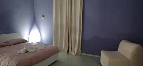 a bedroom with a bed and a white chair at Marico Apartment in Salerno