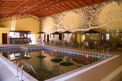 Panari Resort, BW Signature Collection في Nyahururu: مسبح بالطاولات والكراسي والمظلات