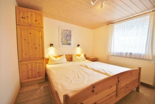 Un dormitorio con una cama grande y una ventana. en Ferienbungalow 4, en Dahme