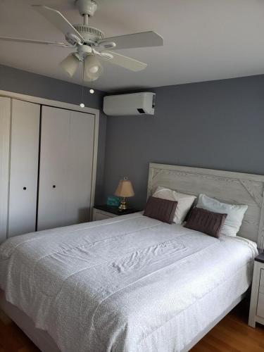 a bedroom with a white bed with a ceiling fan at Beach House in York