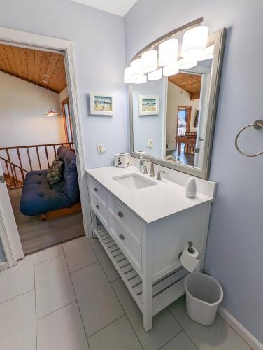 ein Badezimmer mit Waschbecken und Spiegel in der Unterkunft Cedar Cove - Waterfront home with Fire pit! in Deep Hole