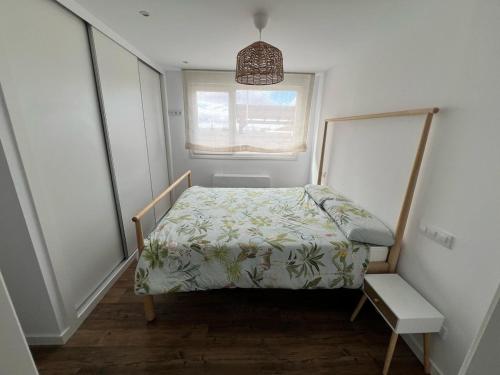 a small bedroom with a bed and a window at El Cubo in La Lastrilla