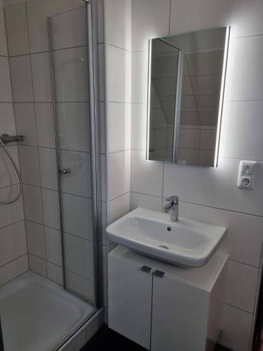 a white bathroom with a sink and a shower at Ferienhaus 10 in Tossens in Tossenserdeich