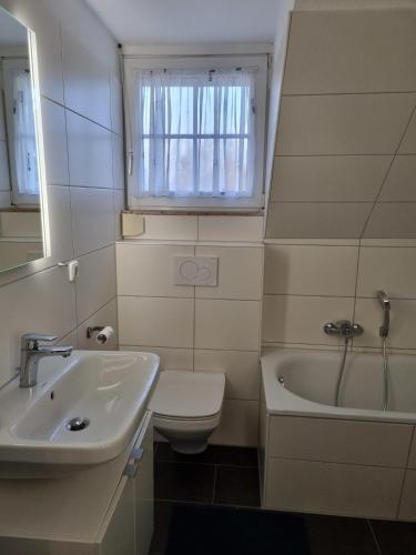 a bathroom with a sink and a toilet and a tub at Ferienhaus 10 in Tossens in Tossenserdeich