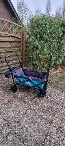 a stroller sitting on a sidewalk next to a fence at Ferienhaus 10 in Tossens in Tossenserdeich