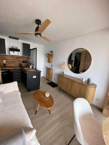 un salon avec un canapé, une table et un miroir dans l'établissement Beach Loft 4 pers, au Barcarès