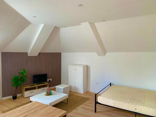 une chambre avec un lit, une télévision et une table dans l'établissement DUPLEX Guingamp centre, à Guingamp