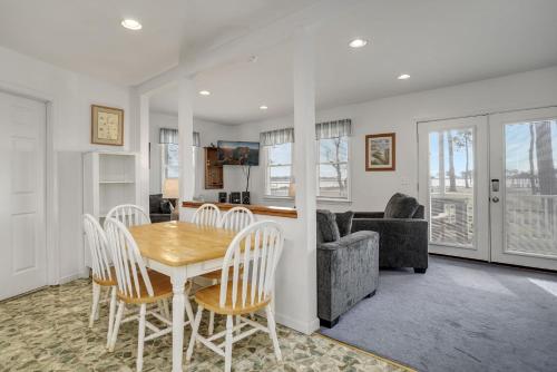 a dining room and living room with a table and chairs at Channel Lookout - Water views & public dock! in Black Point Landing