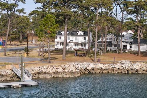 a large white house next to a body of water at Channel Lookout - Water views & public dock! in Black Point Landing