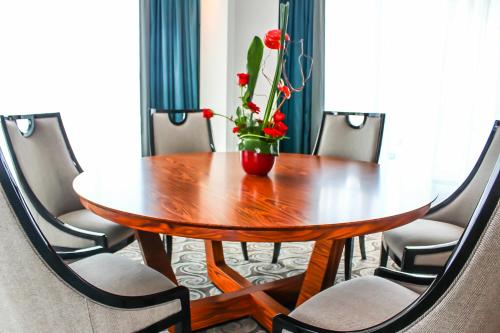 a wooden table with a vase with red flowers on it at Grand Mogador City Center in Casablanca