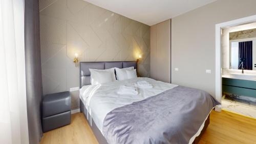 ein Schlafzimmer mit einem großen Bett mit weißer Bettwäsche in der Unterkunft Quiet Luxury Home 2 - home & office in Zalău