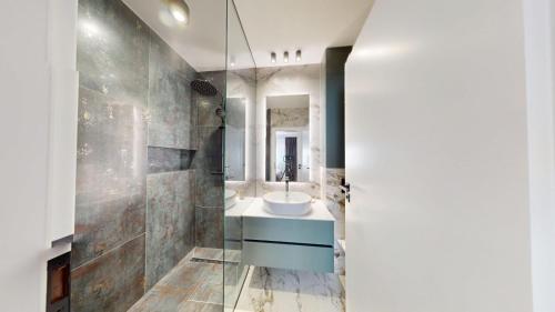 ein Badezimmer mit Waschbecken und Spiegel in der Unterkunft Quiet Luxury Home 2 - home & office in Zalău