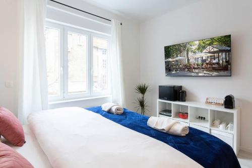 a bedroom with a large white bed with a blue blanket at Lux Nest II City Apartment URBAN STAY in Zagreb