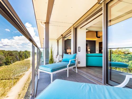 a room with a balcony with blue furniture and glass doors at FeWo Prora - Stella Maris Dachterrasse in Binz