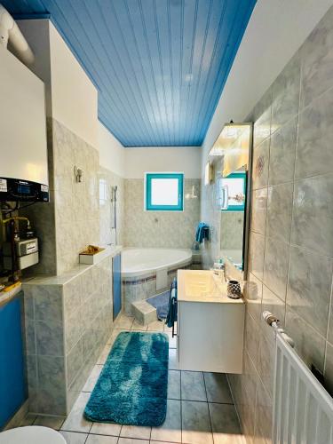 a bathroom with a tub and a sink and a bath tub at Apartment Happy Days Szombathely in Szombathely