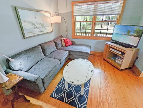 a living room with a couch and a tv at Channel Watch - Waterfront home with private Pier! in Deep Hole