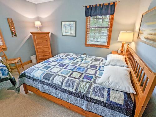 a bedroom with a bed and a dresser at Channel Watch - Waterfront home with private Pier! in Deep Hole