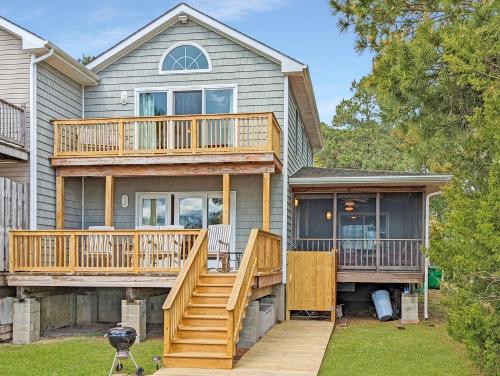 a house with a large deck and a porch at Channel Watch - Waterfront home with private Pier! in Deep Hole