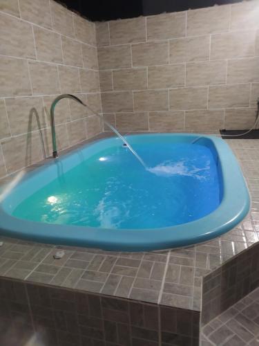 a blue bath tub with a water fountain at Casa com piscina Mongaguá 2 quartos in Mongaguá