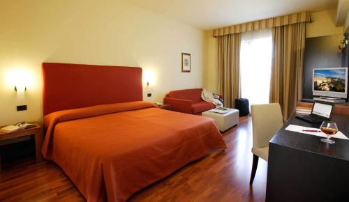 a hotel room with a bed and a chair at Hotel Cristallo di La Rosetta Srl in Assisi
