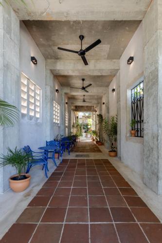a hallway with blue chairs and a ceiling fan at El Mambo Boutique Hotel in Las Terrenas