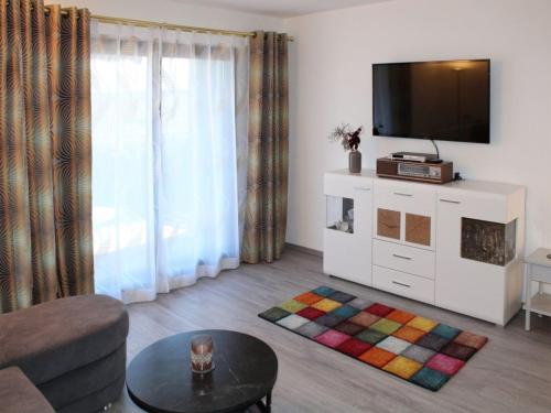 un salon avec une télévision et un canapé dans l'établissement Ferienhaus Nr 134, Kategorie Komfort, Feriendorf Hochbergle, Allgäu, à Lechbruck am See