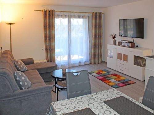 un salon avec un canapé et une télévision dans l'établissement Ferienhaus Nr 134, Kategorie Komfort, Feriendorf Hochbergle, Allgäu, à Lechbruck am See