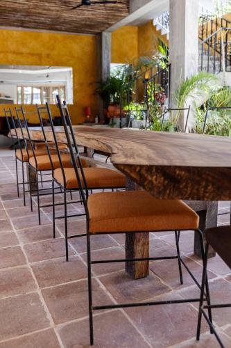 a row of chairs around a large wooden table at El Mambo Boutique Hotel in Las Terrenas