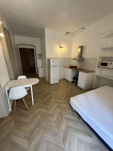 Cette chambre comprend un lit, une table et une cuisine. dans l'établissement Charmant studio cours Paoli, à Corte