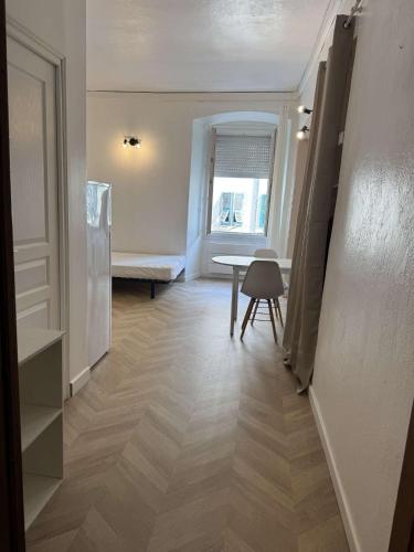un couloir avec une chambre dotée d'une table et d'une fenêtre dans l'établissement Charmant studio cours Paoli, à Corte
