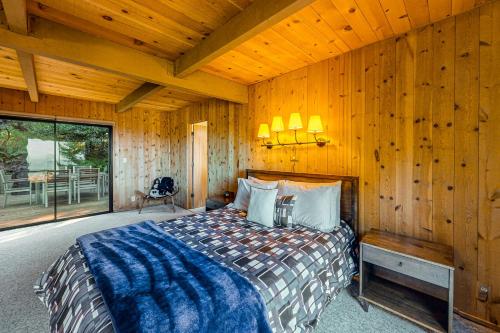 ein Schlafzimmer mit einem Bett in einem Zimmer mit Holzwänden in der Unterkunft Moonraker in Sea Ranch