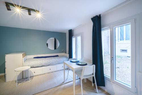 une chambre avec un lit, une table et des chaises dans l'établissement L'Atelier Lobau Nancy - Studio Élégant en Centre-Ville, à Nancy