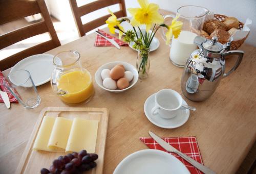 einen Tisch mit Käse und Eiern und einen Krug Orangensaft in der Unterkunft Bauernhof Höper-Rauert - Reihenhaus 1 in Neujellingsdorf