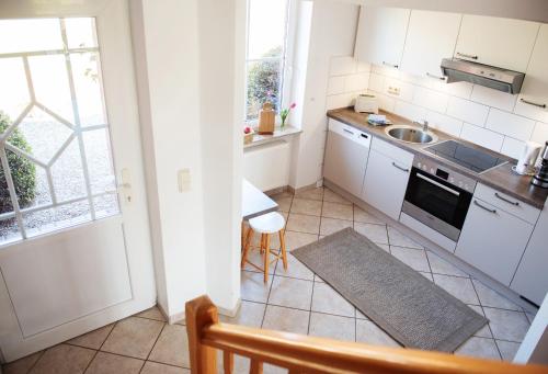 eine Küche mit Spüle und Herd oberen Backofen in der Unterkunft Bauernhof Höper-Rauert - Reihenhaus 7 in Neujellingsdorf