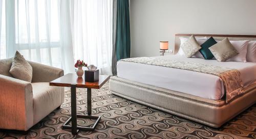 a bedroom with a large bed and a couch at Grand Mogador City Center in Casablanca