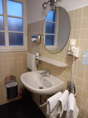 a bathroom with a sink and a mirror and towels at Altstadt Oase Bernkastel-kues in Bernkastel-Kues