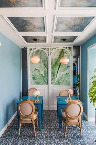 a room with two blue tables and two chairs at Villa Oteri Rooms & Bistrot in Bacoli