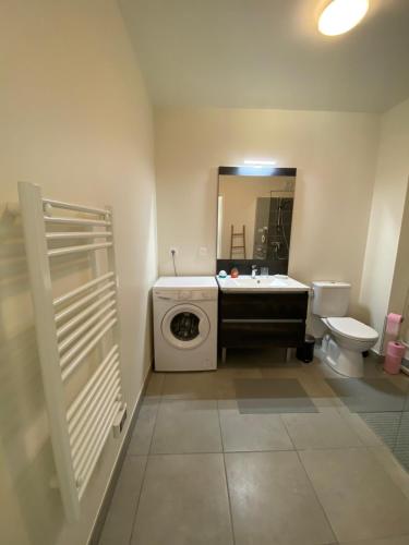 une salle de bain avec une machine à laver et un lavabo dans l'établissement Appartement Remember à 700m de l'Océan, à Mimizan-Plage