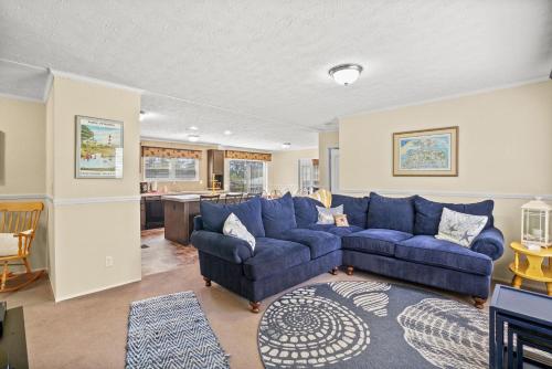 a living room with a blue couch and a kitchen at Charlie's Cove - Pet friendly w/ Fenced yard! in Black Point Landing