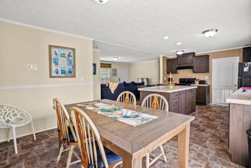 a kitchen and living room with a wooden table and chairs at Charlie's Cove - Pet friendly w/ Fenced yard! in Black Point Landing