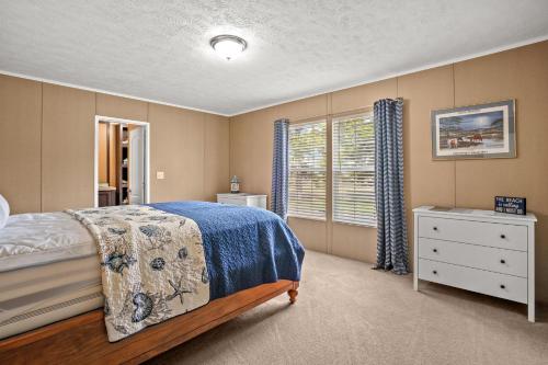 a bedroom with a bed and a dresser and a window at Charlie's Cove - Pet friendly w/ Fenced yard! in Black Point Landing