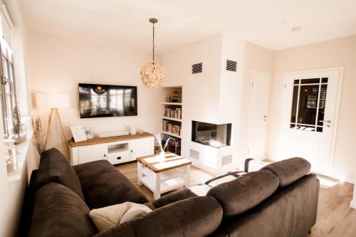 a living room with a brown couch and a tv at Ferienhaus Meeresschatz in Zingst