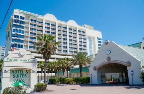 ein Hotel und Suiten vor einem Gebäude unterzeichnen in der Unterkunft Amazing Ocean View Beachfront Entire Apartment Direct access to Beach in Daytona Beach