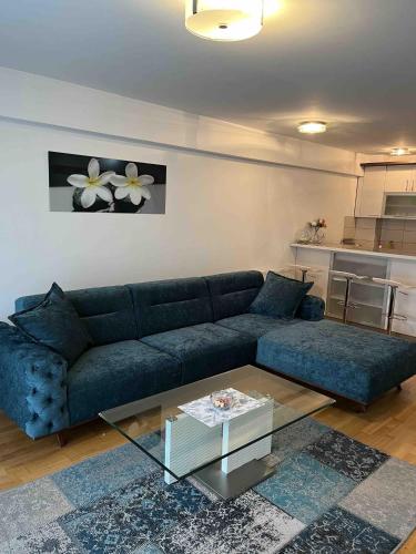 a living room with a blue couch and a glass table at Sarajevo Apartment Ilidza in Sarajevo