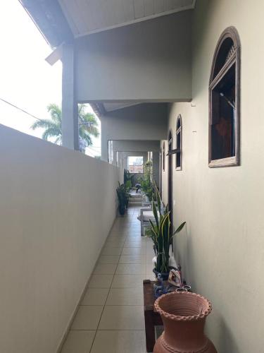 einen Flur mit Topfpflanzen in einem Haus in der Unterkunft Raízes Pousada in Porto Seguro