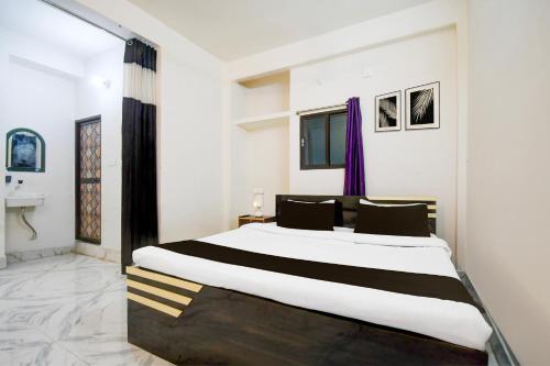 a bedroom with a large bed and a sink at Hotel O The Light Hotel in Patna