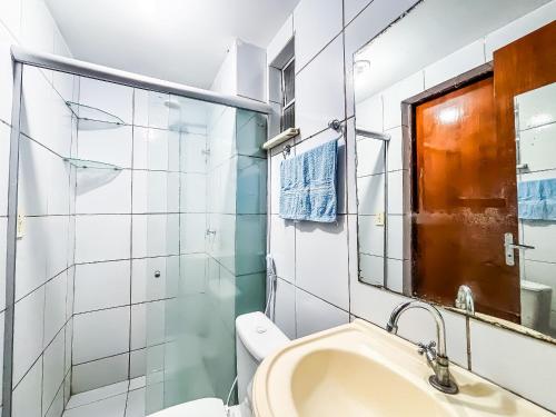 a bathroom with a sink and a toilet and a mirror at Apê Confortável com Piscina I Wi-Fi e A/C in Imperatriz