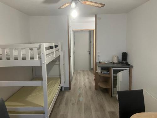 Cette petite chambre comprend des lits superposés et un bureau. dans l'établissement studio cap d'agde, au Cap d'Agde