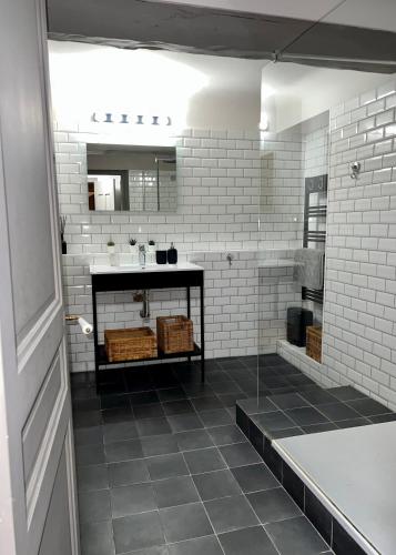 La salle de bains est pourvue d'un lavabo et d'un mur en briques blanches. dans l'établissement Maison Alberta, à Aix-en-Provence