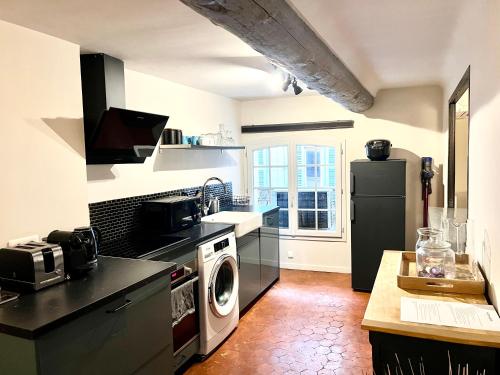 une cuisine avec un réfrigérateur et une machine à laver dans l'établissement Maison Alberta, à Aix-en-Provence